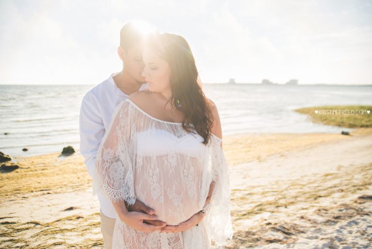 couple maternity posing on the beach in Tampa FL, Kristine Freed Photography
