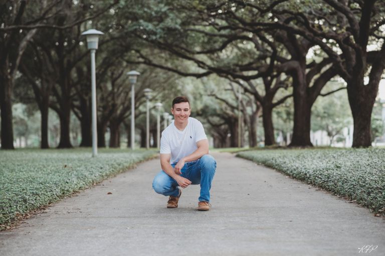 senior boy on tree-lined walkway