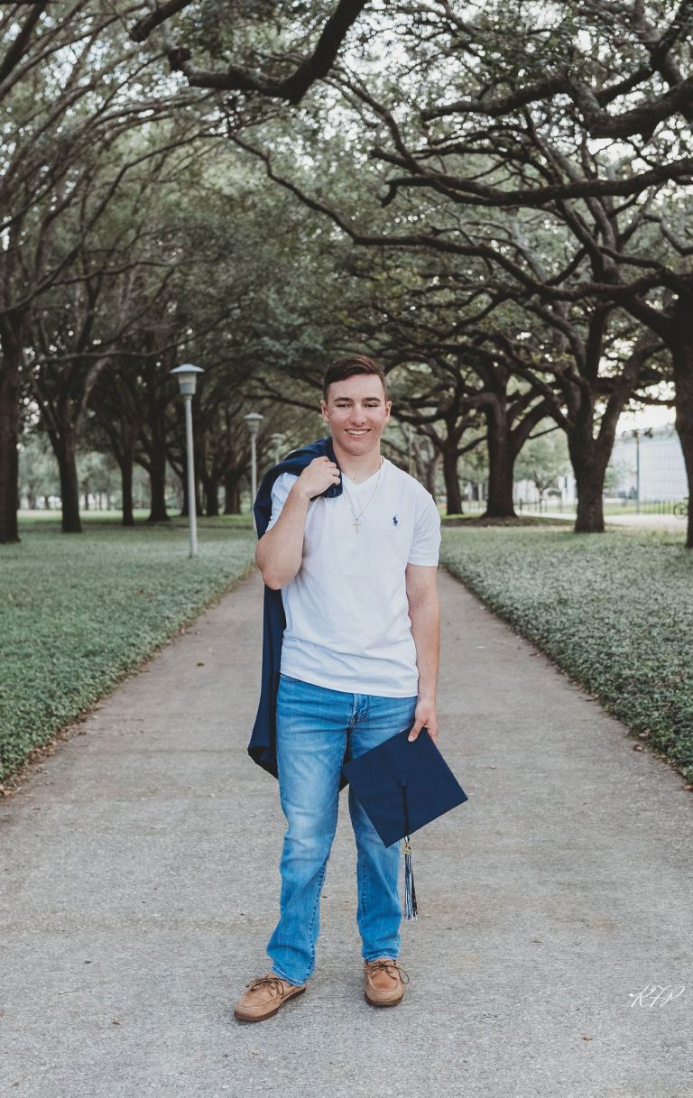 senior boy holding cap and gown