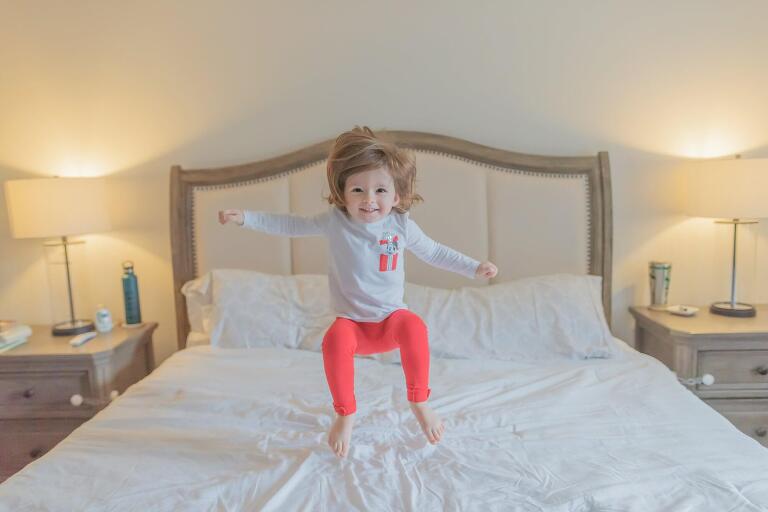 big sister jumping on bed