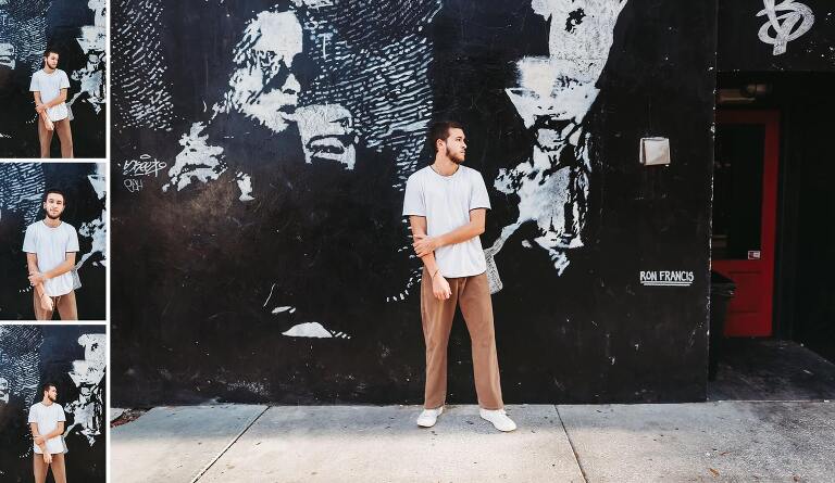 senior boy in front of graffiti wall