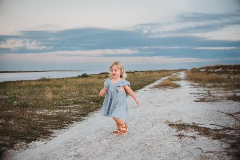 little girl running on sandy path