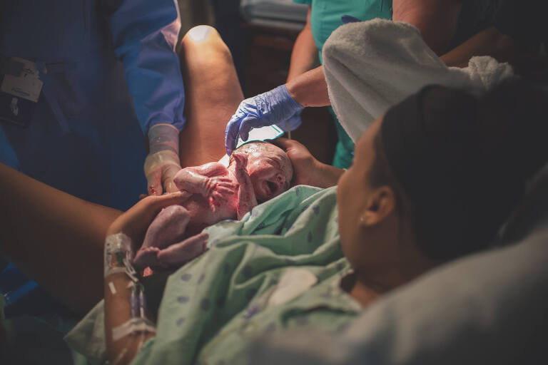 mom holding baby just born, talking about cost of birth photography